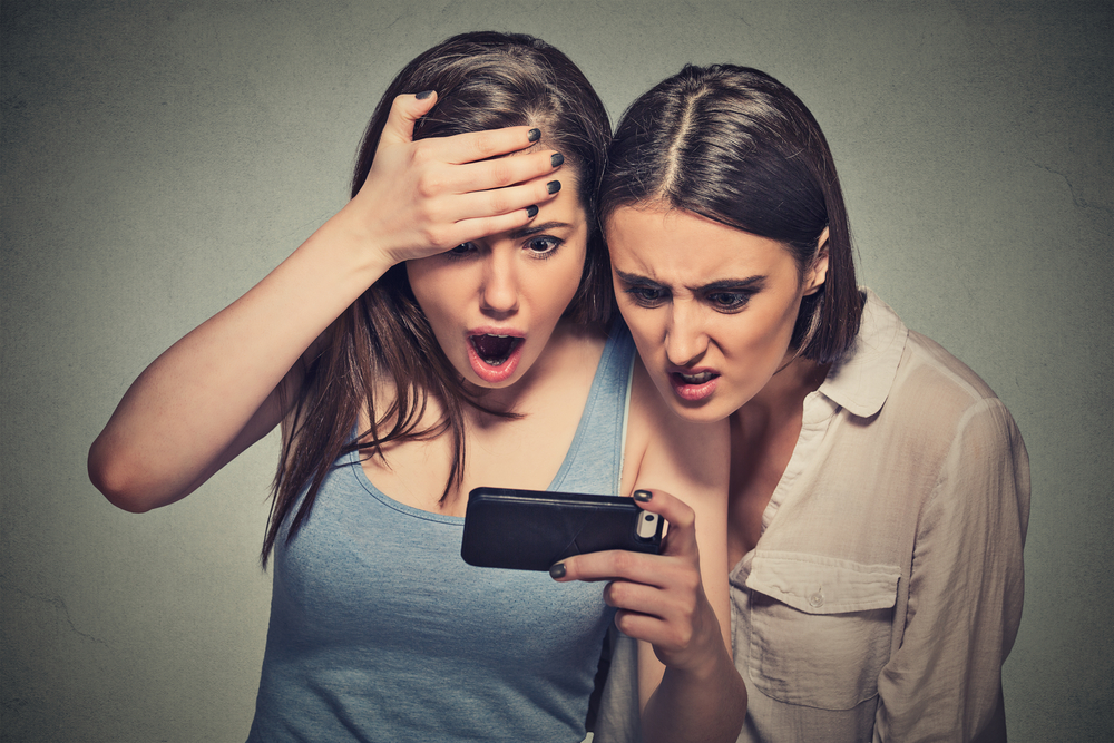 two girls shocked looking at phone